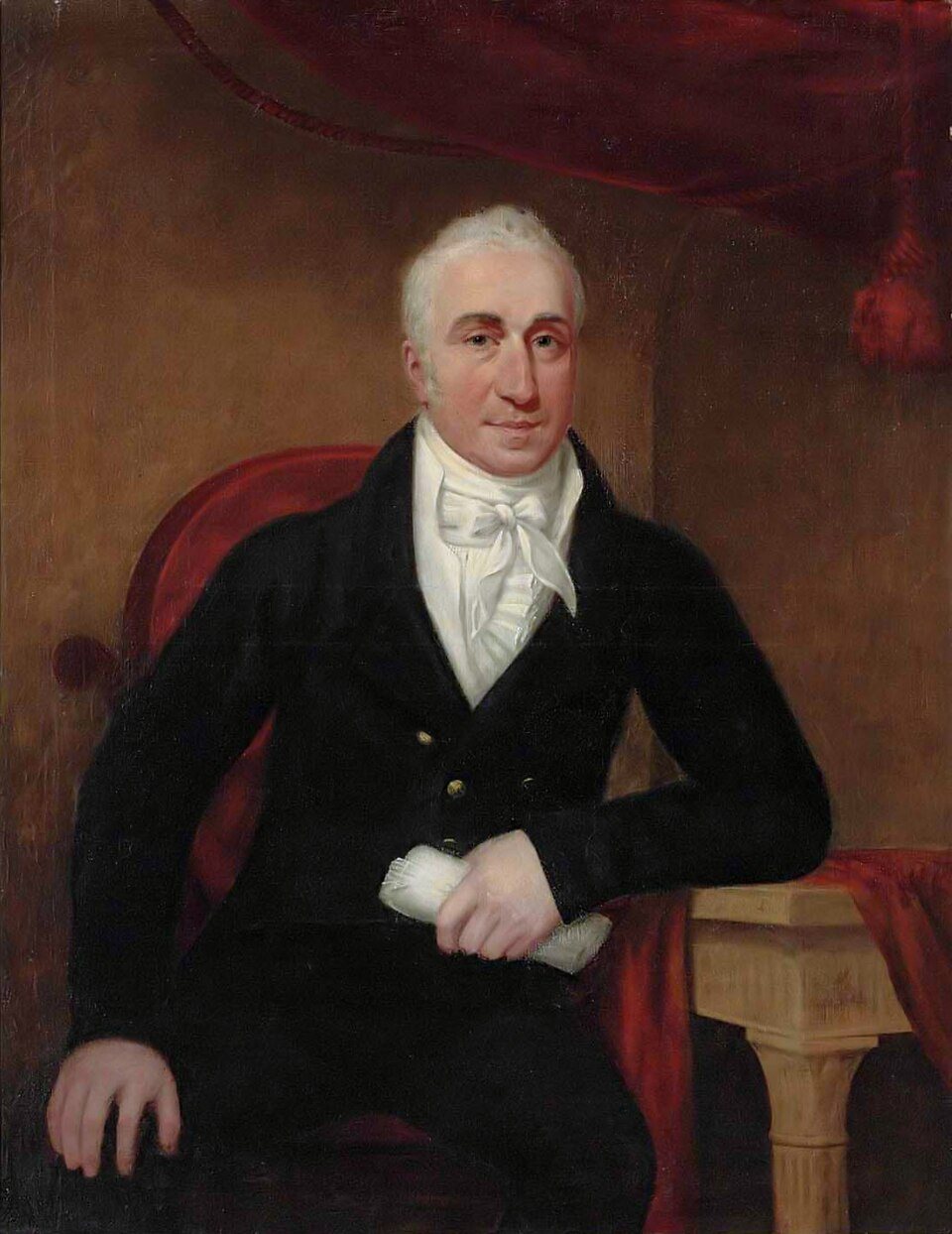 Portrait of a seated man in a dark coat holding a rolled paper